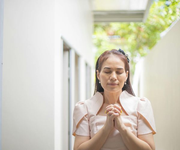 Person meditating peacefully outdoors with a serene natural background.